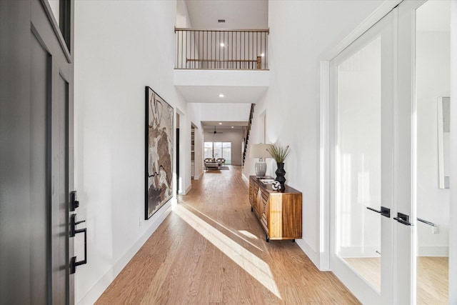 entrance foyer featuring a high ceiling, light wood-type flooring, and french doors