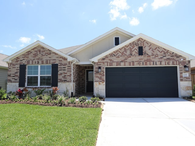 ranch-style house with driveway, a front yard, a garage, brick siding, and stone siding