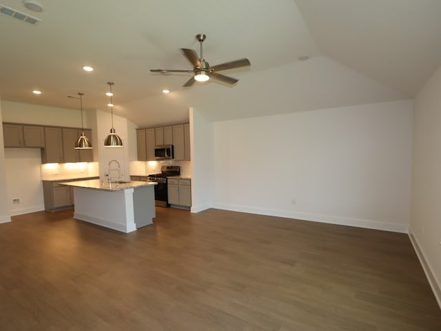 kitchen with a center island with sink, vaulted ceiling, gray cabinetry, and stainless steel appliances