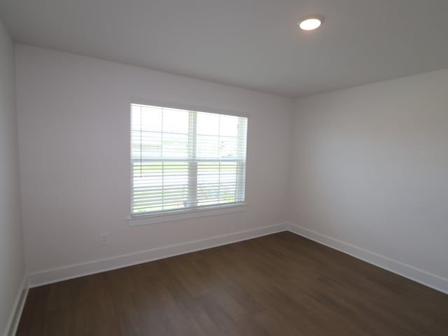 unfurnished room featuring baseboards, recessed lighting, and dark wood-type flooring