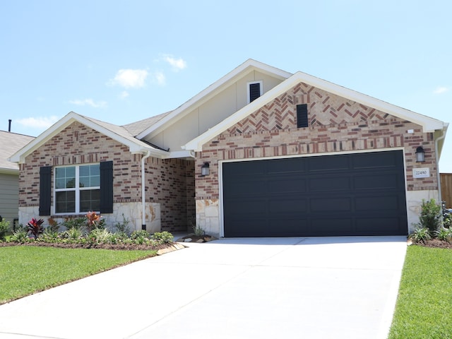 single story home featuring a front lawn, stone siding, brick siding, concrete driveway, and an attached garage
