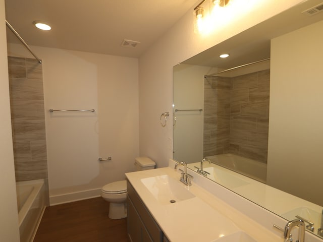 bathroom with toilet, visible vents, wood finished floors, and bathtub / shower combination