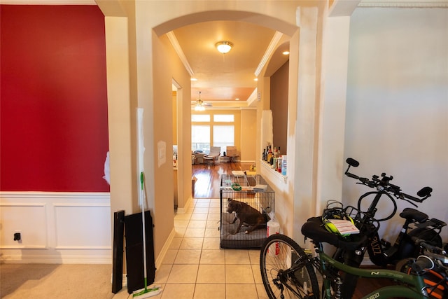 corridor featuring light tile patterned floors and ornamental molding