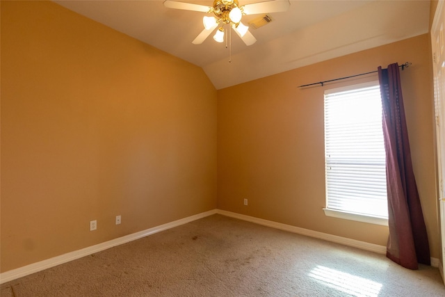 carpeted empty room with a wealth of natural light, lofted ceiling, and ceiling fan