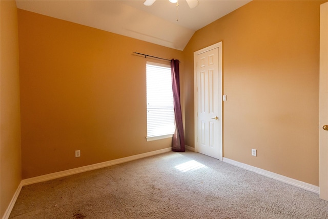 carpeted spare room with ceiling fan and lofted ceiling