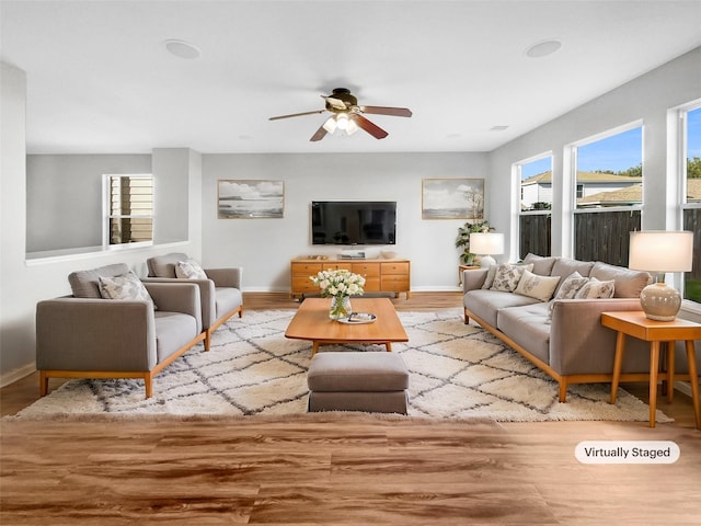 living room featuring light hardwood / wood-style flooring and ceiling fan