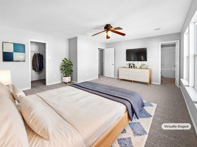 bedroom featuring carpet flooring, a walk in closet, ensuite bathroom, ceiling fan, and a closet