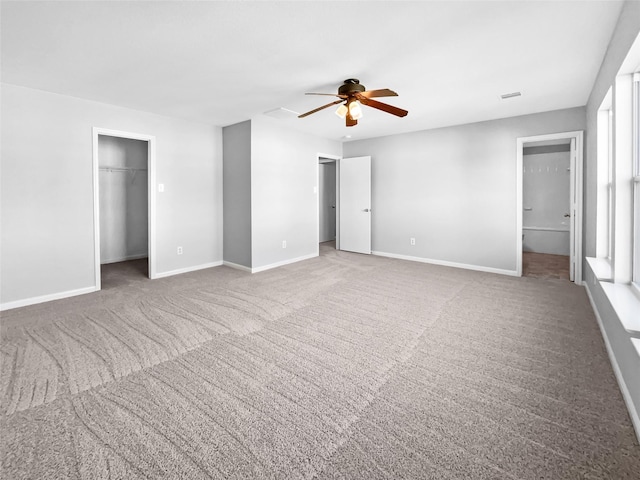 unfurnished bedroom featuring ensuite bath, ceiling fan, and carpet floors