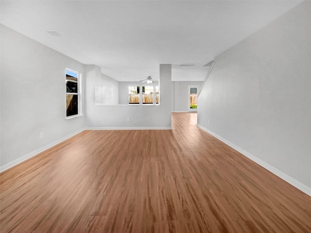 unfurnished living room with ceiling fan and wood-type flooring