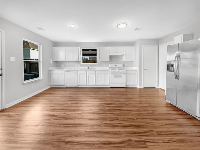 kitchen with hardwood / wood-style floors, white appliances, white cabinetry, and sink