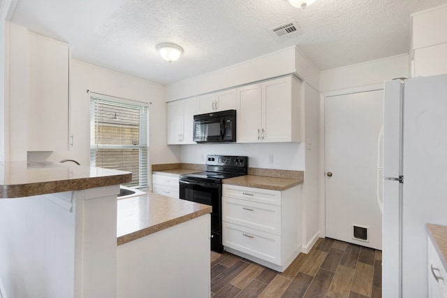 kitchen with dark hardwood / wood-style floors, kitchen peninsula, a textured ceiling, white cabinets, and black appliances