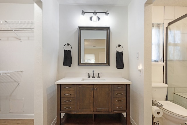 bathroom featuring a shower, wood-type flooring, vanity, and toilet