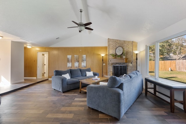 living room featuring a brick fireplace, ceiling fan, dark hardwood / wood-style floors, lofted ceiling, and wood walls