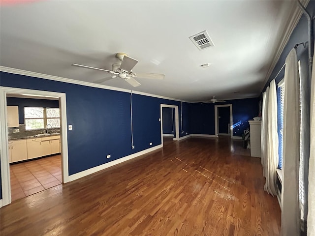 unfurnished living room featuring dark hardwood / wood-style flooring, ceiling fan, ornamental molding, and sink