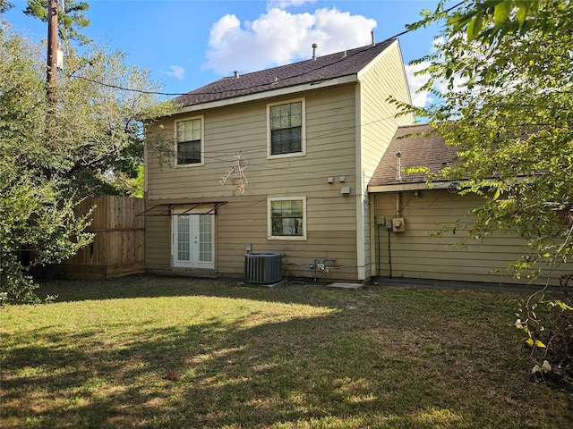 back of property with central air condition unit and a lawn