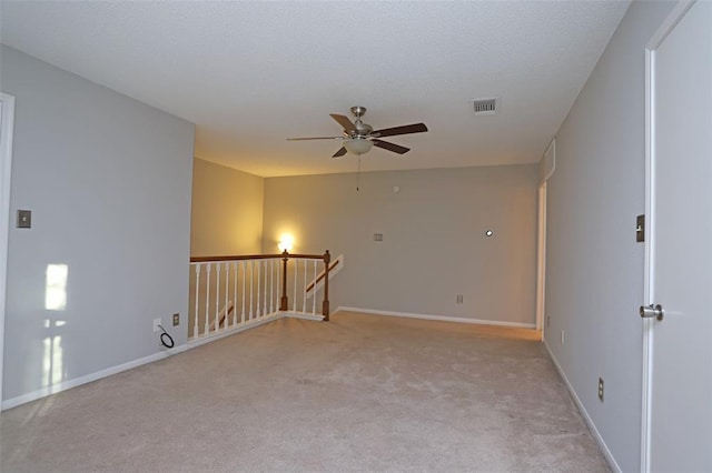 carpeted spare room featuring ceiling fan