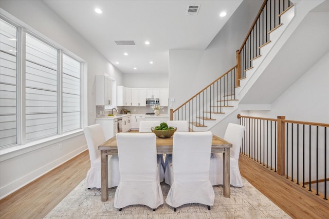 dining space with sink and light hardwood / wood-style floors