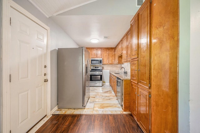 kitchen with hardwood / wood-style flooring, sink, appliances with stainless steel finishes, and tasteful backsplash