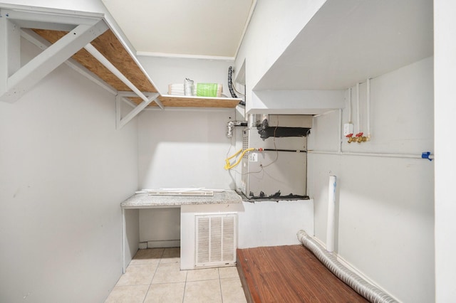 walk in closet with heating unit and light tile patterned floors