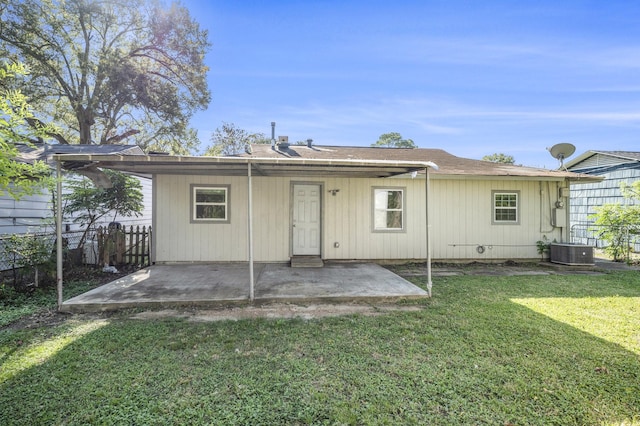 rear view of house with central air condition unit, a patio area, and a yard