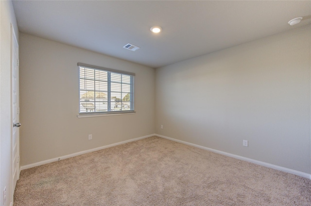 spare room featuring light carpet