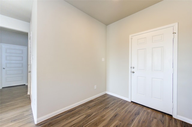 unfurnished room with dark wood-type flooring