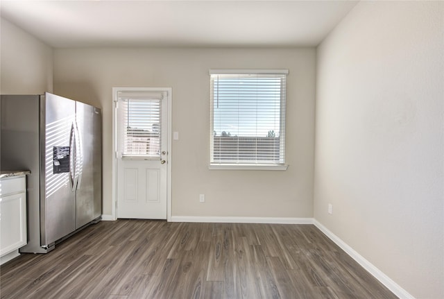 kitchen featuring stainless steel fridge, white cabinets, and dark wood-type flooring