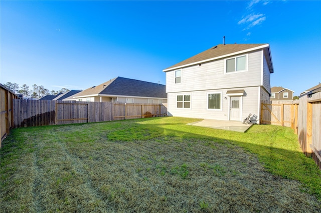 back of house featuring a lawn and a patio area