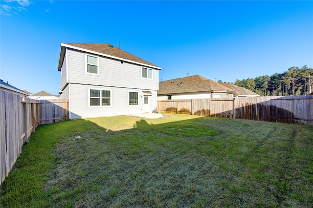 rear view of property with a yard and a patio area