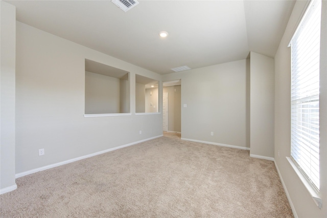 spare room featuring light carpet and a healthy amount of sunlight