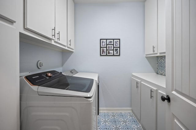 laundry area with cabinets, light tile patterned floors, and washer and dryer