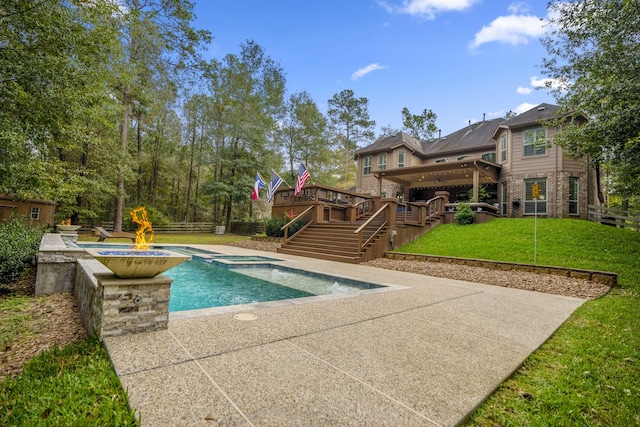 view of pool with a patio area, a yard, an in ground hot tub, and a wooden deck