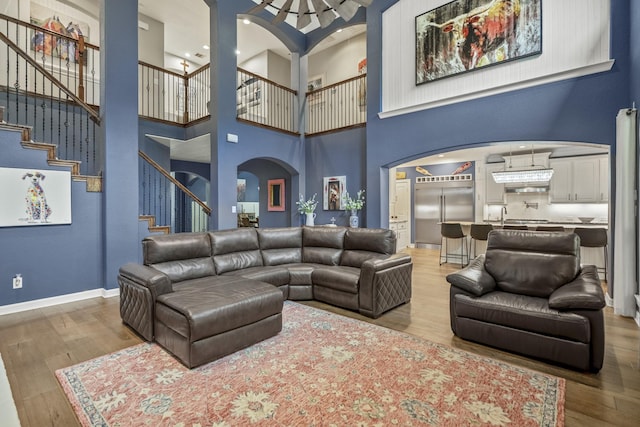 living room featuring hardwood / wood-style flooring and a towering ceiling