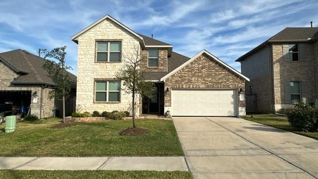 view of property featuring a garage and a front yard