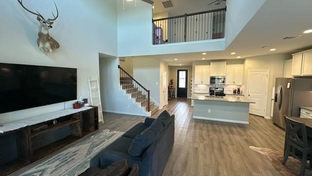 living room with wood-type flooring and a high ceiling