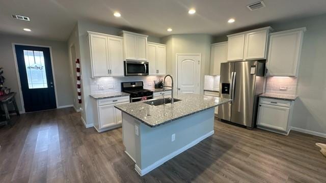 kitchen featuring stainless steel appliances, dark wood-type flooring, sink, white cabinetry, and an island with sink