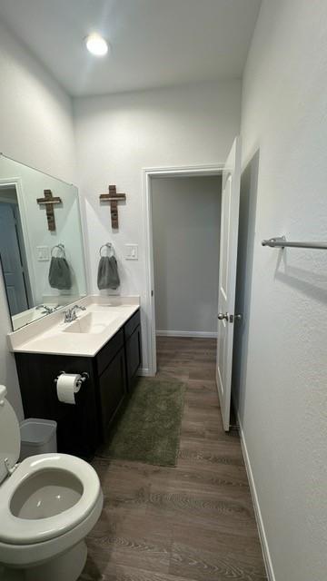 bathroom with toilet, vanity, and hardwood / wood-style flooring