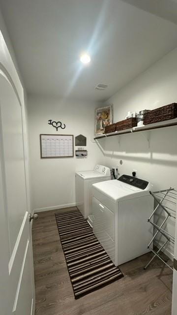 laundry room with washer and clothes dryer and dark hardwood / wood-style flooring