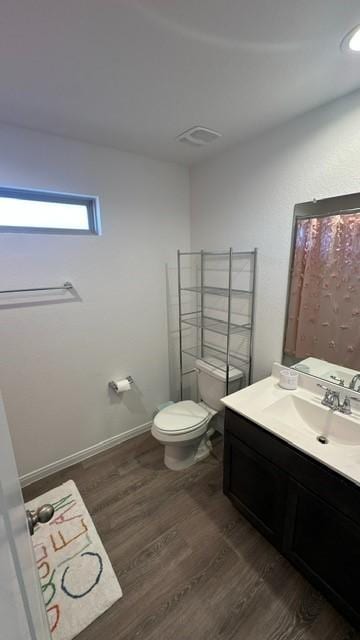 bathroom featuring wood-type flooring, vanity, and toilet