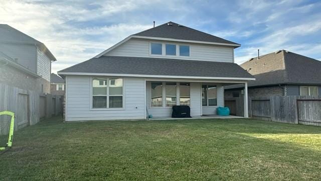 rear view of property featuring a yard