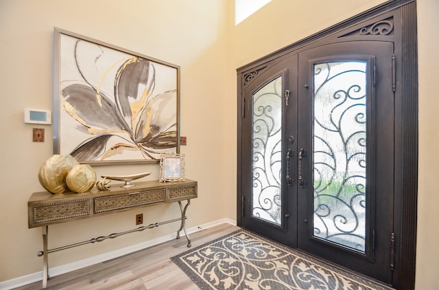 foyer entrance with hardwood / wood-style flooring and french doors