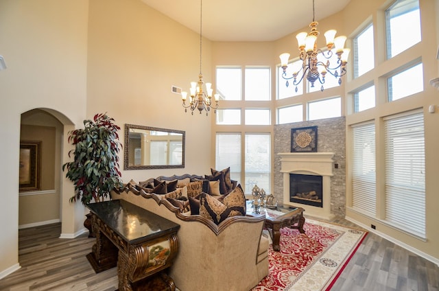 living room with a high ceiling, plenty of natural light, and wood-type flooring