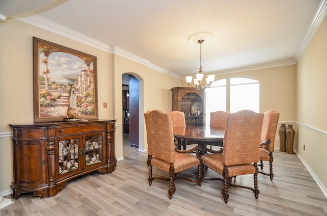 dining room featuring a notable chandelier, light hardwood / wood-style floors, and crown molding