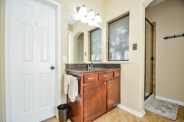 bathroom featuring a shower with door, vanity, and tile patterned flooring