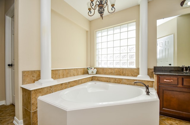 bathroom with a chandelier, vanity, a tub to relax in, and tile patterned flooring