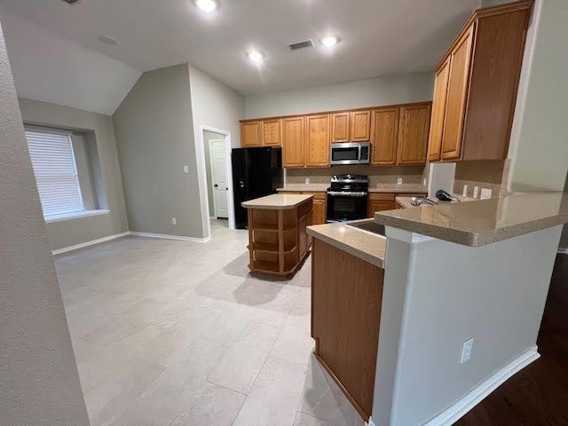 kitchen with black appliances, a center island, kitchen peninsula, and vaulted ceiling