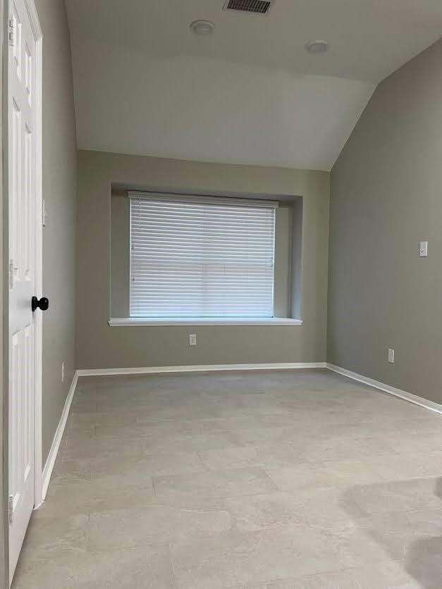 empty room featuring lofted ceiling