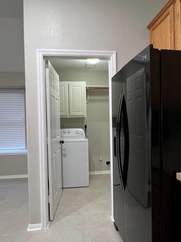 washroom featuring cabinets and washer / clothes dryer