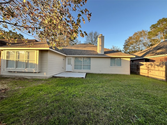 rear view of house featuring a lawn and a patio area