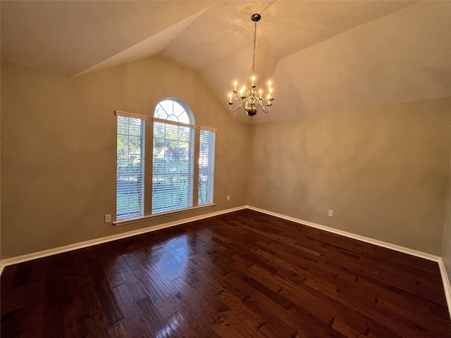 empty room featuring hardwood / wood-style floors, lofted ceiling, and a notable chandelier